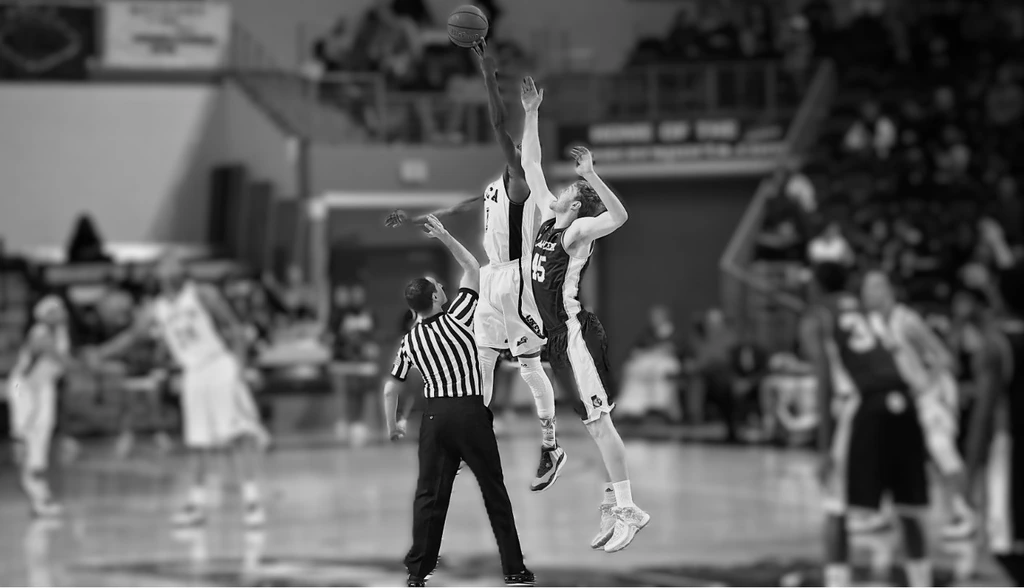 Basketball official positioned at center court during a tip-off
